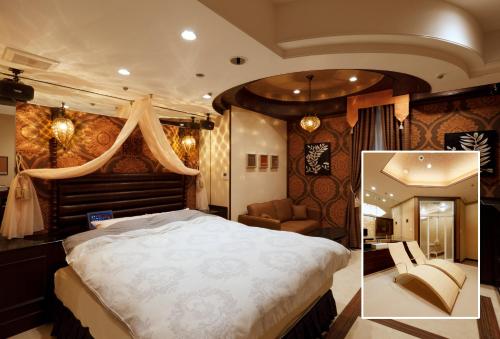 ein Schlafzimmer mit einem großen Bett und einem Sofa in der Unterkunft Osyare Kizoku Ichinomiya (Adult Only) in Ichinomiya
