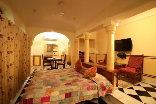 a bedroom with a bed and a table and chairs at Khatu Haveli in Jaipur
