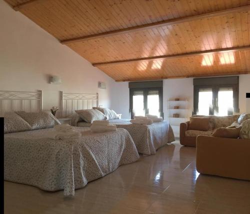 a large bedroom with two beds and a couch at Casa vacacional El Arroyo in Ferreras de Arriba