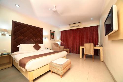 Un pat sau paturi într-o cameră la Chryso Hotels Pvt Ltd
