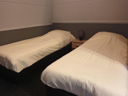 two beds sitting next to each other in a room at Hotel,cafe,biljart POT in Groenlo