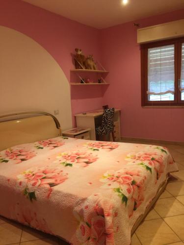 Un dormitorio con una cama con flores. en la casa di Ale, en Manciano