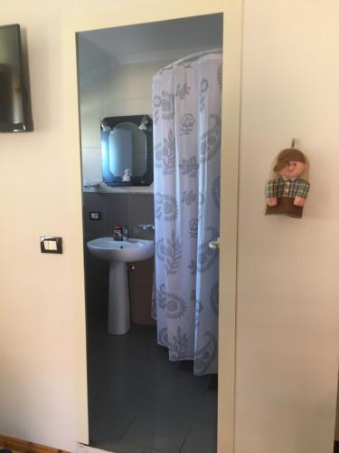 a bathroom with a shower curtain and a sink at Lille France Apartments in Shkodër