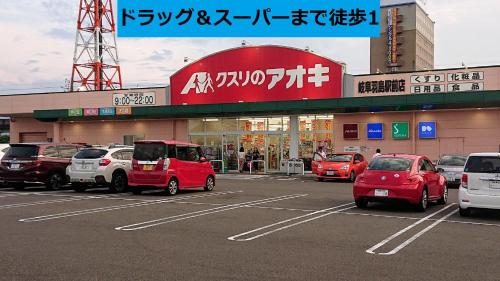 a parking lot with cars parked in front of a store at ゲストハウス岐阜羽島心音 Guest House Gifuhashima COCONE in Hashima