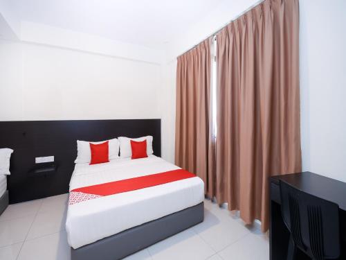 a bedroom with a bed with red pillows at Kenyalang Suite in Miri