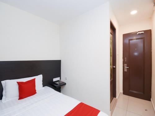 a bedroom with a bed with a red pillow at Kenyalang Suite in Miri