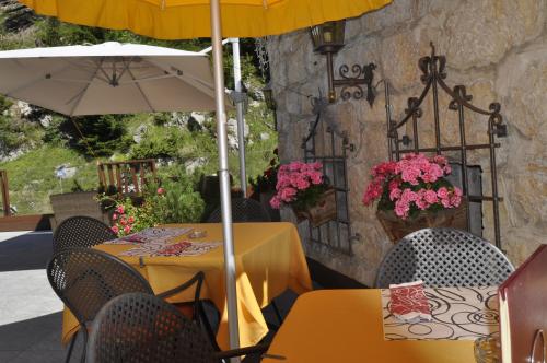 two tables with umbrellas on a patio at Hotel Al Forte in Arabba