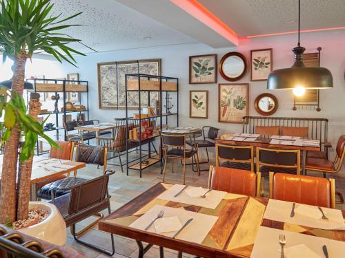 a restaurant with tables and chairs in a room at BelleVue Club in Port d'Alcudia