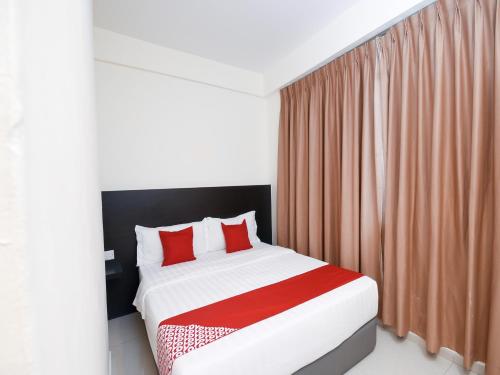 a bedroom with a large bed with red pillows at Kenyalang Suite in Miri