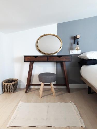 a dressing table with a mirror and a stool at La Mar de Ben in Muros