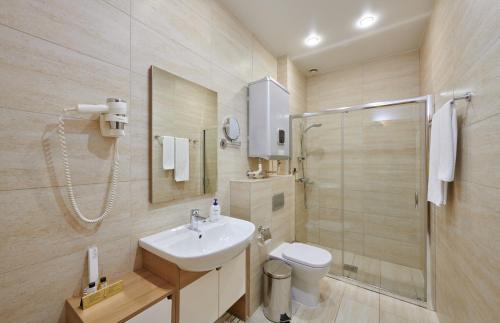 a bathroom with a toilet, sink, and shower at Metelitsa Hotel in Krasnoyarsk