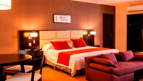 a bedroom with a bed and a table and a couch at Howard Johnson Hotel & Casino in Formosa