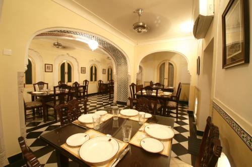 a restaurant with tables and chairs in a room at Khatu Haveli in Jaipur