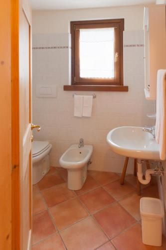 a bathroom with a toilet and a sink at Residence Bait da Mott in Livigno