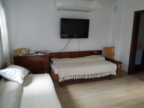 a living room with two beds and a flat screen tv at Bobekova Kashta in Panagyurishte