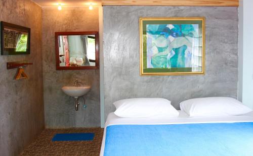 a bedroom with a bed and a sink in it at Tea Moon Beach House in Thongsala