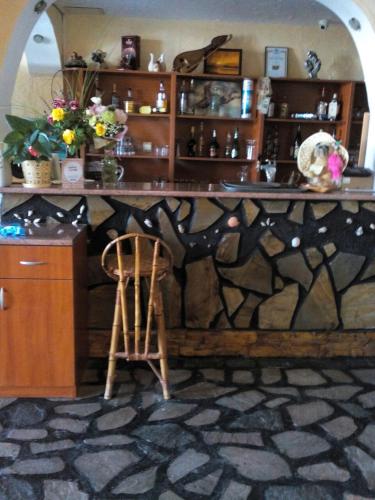 a bar with a wooden counter and a wooden chair at Guest House Hetodon in Sozopol
