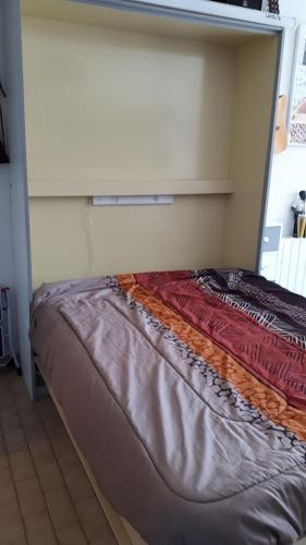 - un lit dans l'angle de la chambre dans l'établissement Studio 250m mer et Seaquarium avec place parking, au Grau-du-Roi