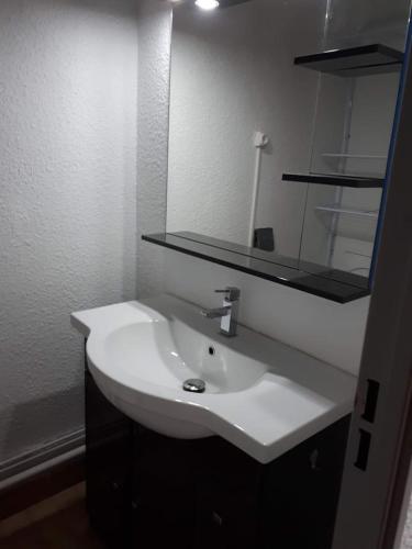 y baño con lavabo blanco y espejo. en Studio 250m mer et Seaquarium avec place parking en Le Grau-du-Roi