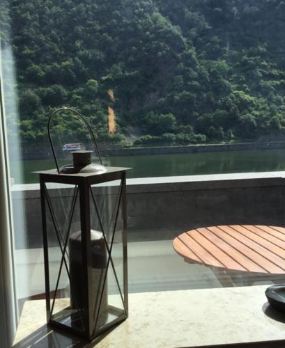 a table sitting on a balcony with a view of the water at Altes Fachwerkhaus Mutter Mosel in Löf