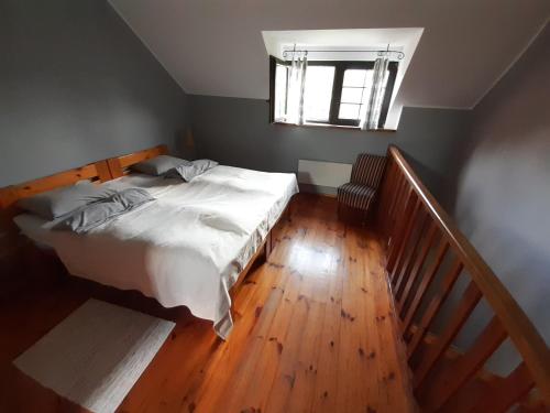 a bedroom with a bed and a wooden floor at Natura Apartamenty in Swaderki