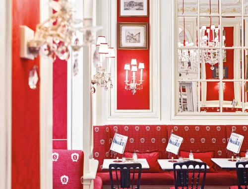 a restaurant with red walls and tables and chairs at Hotel Sacher Wien in Vienna