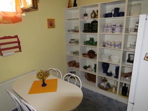 a dining room with a table and a shelf of dishes at Pásztor Fogadó in Martfů