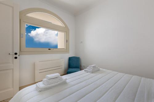 Habitación blanca con cama y ventana en Relais Carlo Alberto en Salve