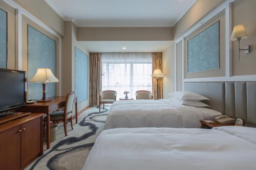 a hotel room with two beds and a television at Chongqing Liyuan Hotel in Chongqing