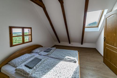 a bedroom with a bed in a room with windows at Tagyon Birtok Kései szüret Apartmanház in Tagyon