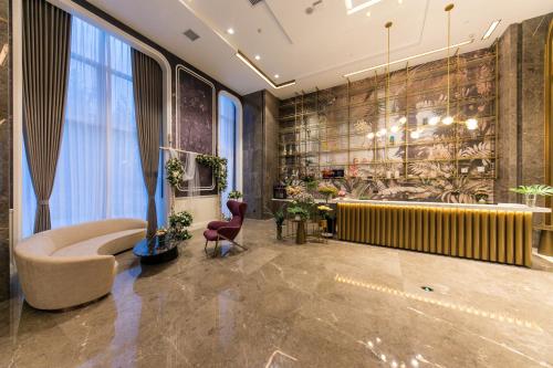 a lobby with a waiting area with a couch and chairs at Mercure Xi'an Qujiang in Xi'an