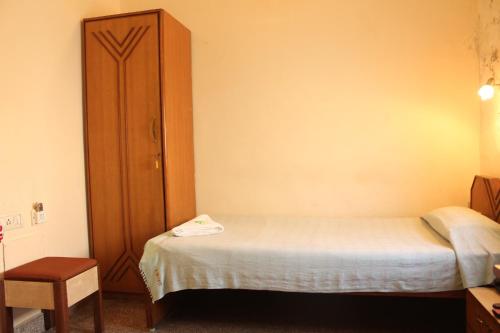 a small bedroom with a bed and a wooden cabinet at YWCA International Centre in Mumbai