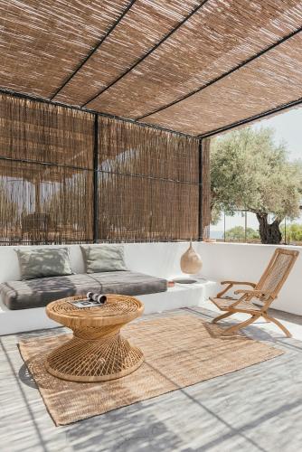 a living room with a table and a couch and a chair at Casita Casita Lindos - Adults Only in Líndos