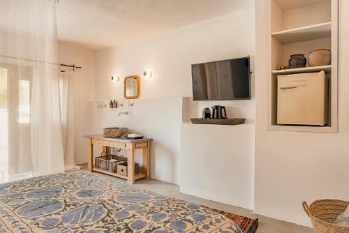 a room with a bed and a tv on a wall at Casita Casita Lindos - Adults Only in Líndos