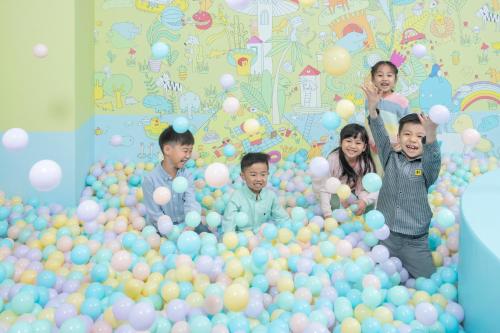 a group of children standing in a ball pit of balloons at Dorsett Tsuen Wan, Hong Kong in Hong Kong