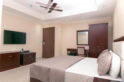 a bedroom with a bed and a flat screen tv at Monarch Hotel in Accra