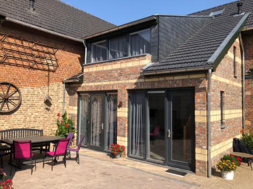 an extension to a brick building with a table and chairs at de hooiberg in Walem