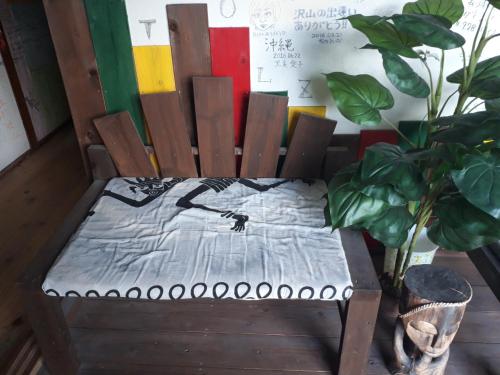 a wooden chair with a blanket on top of it at backpackers guesthouse Border in Nago