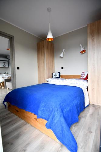 a bedroom with a large bed with a blue blanket at Zamkowe Wzgórze in Niedzica Zamek