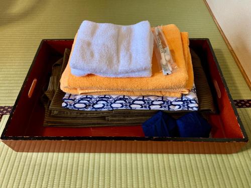 Una caja de madera con toallas y toallas. en Kirishimaya Ryokan, en Kusatsu