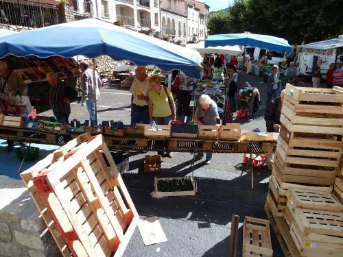 a group of people at an outdoor market with wooden crates at Maison Baxter in Prats-de-Mollo-la-Preste