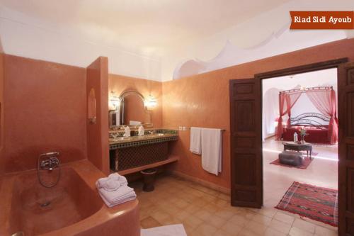 een grote badkamer met een bad en een wastafel bij Riad Sidi Ayoub in Marrakesh