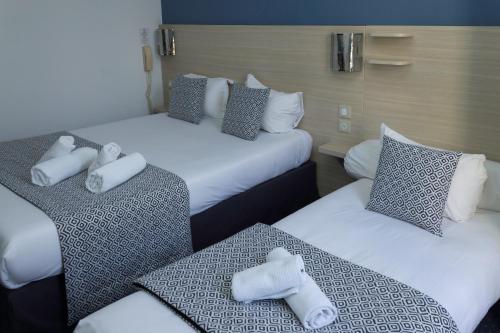 A bed or beds in a room at Hôtel de Paris La Défense