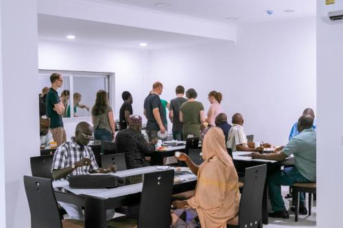 a group of people sitting at tables in a room at Monarch Hotel in Accra