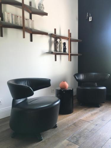a room with two black chairs and shelves at Le Clos de la Pomponnette in Pomponne