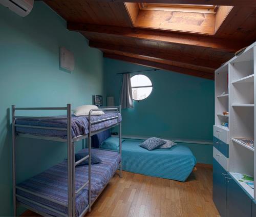 a room with two bunk beds and a wooden ceiling at B&B Family House Franciacorta in Corte Franca