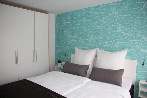 a bedroom with a bed with a green wall at Appartementanlage Lancken-Granitz in Lancken-Granitz