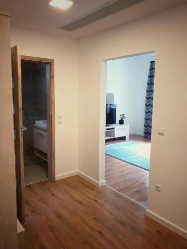 an empty room with a door open to a living room at Moment Apartments in Szolnok