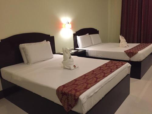 a hotel room with two beds and a lamp at Hollywood Suites in General Santos