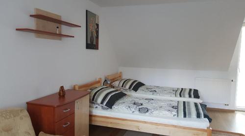 a small bedroom with a bed and a dresser at Pełny Relaks - Sajenek in Augustów